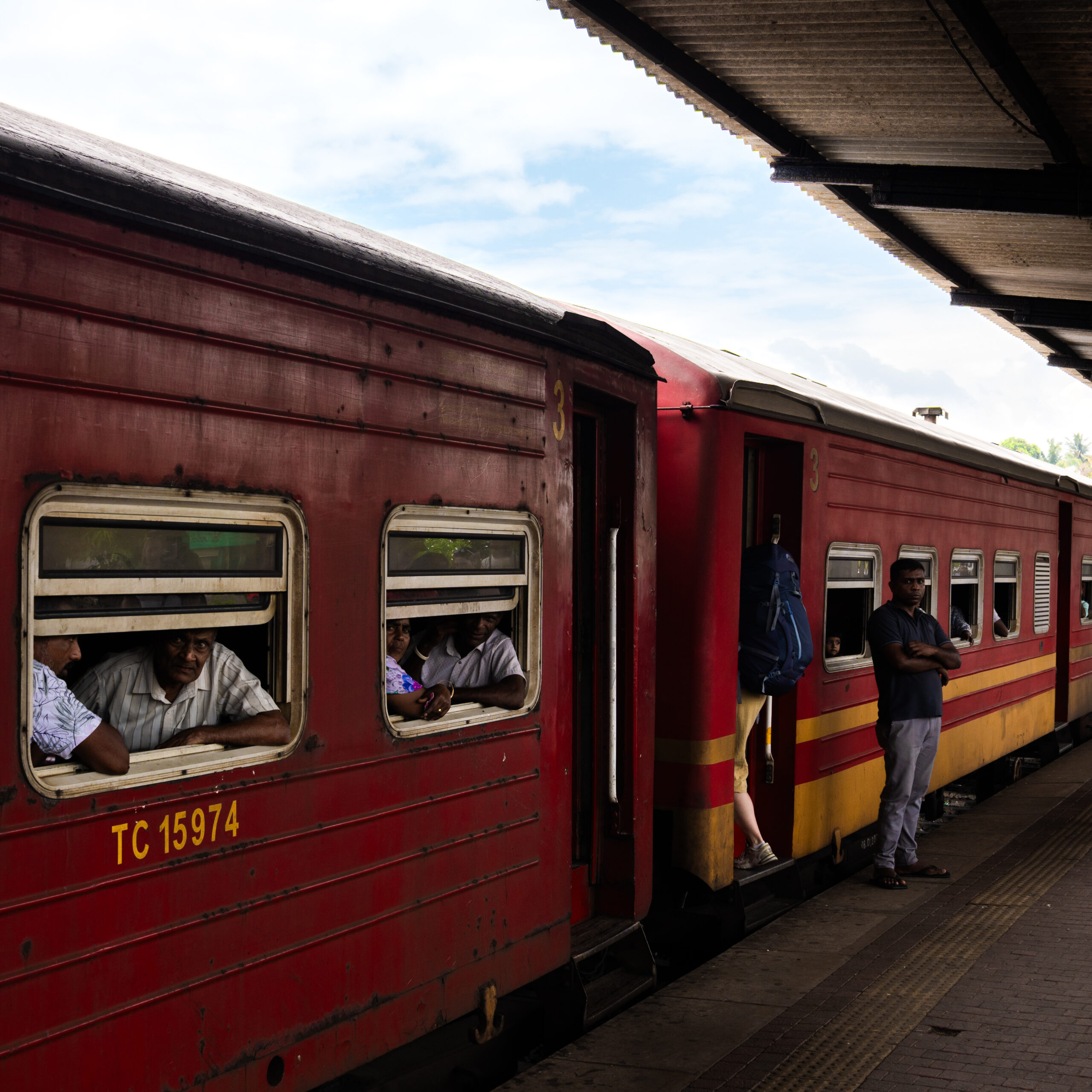 A train heading along the coast in Sri Lanka, Travellers using it as their budget-friendly transport method.