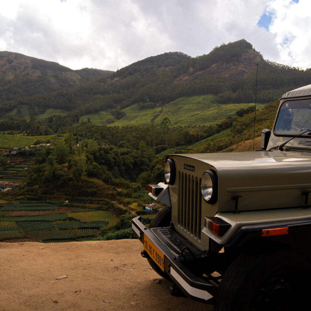 Our jeep pulled up against a lush green landscape during the Munnar Jeep Tours, India.