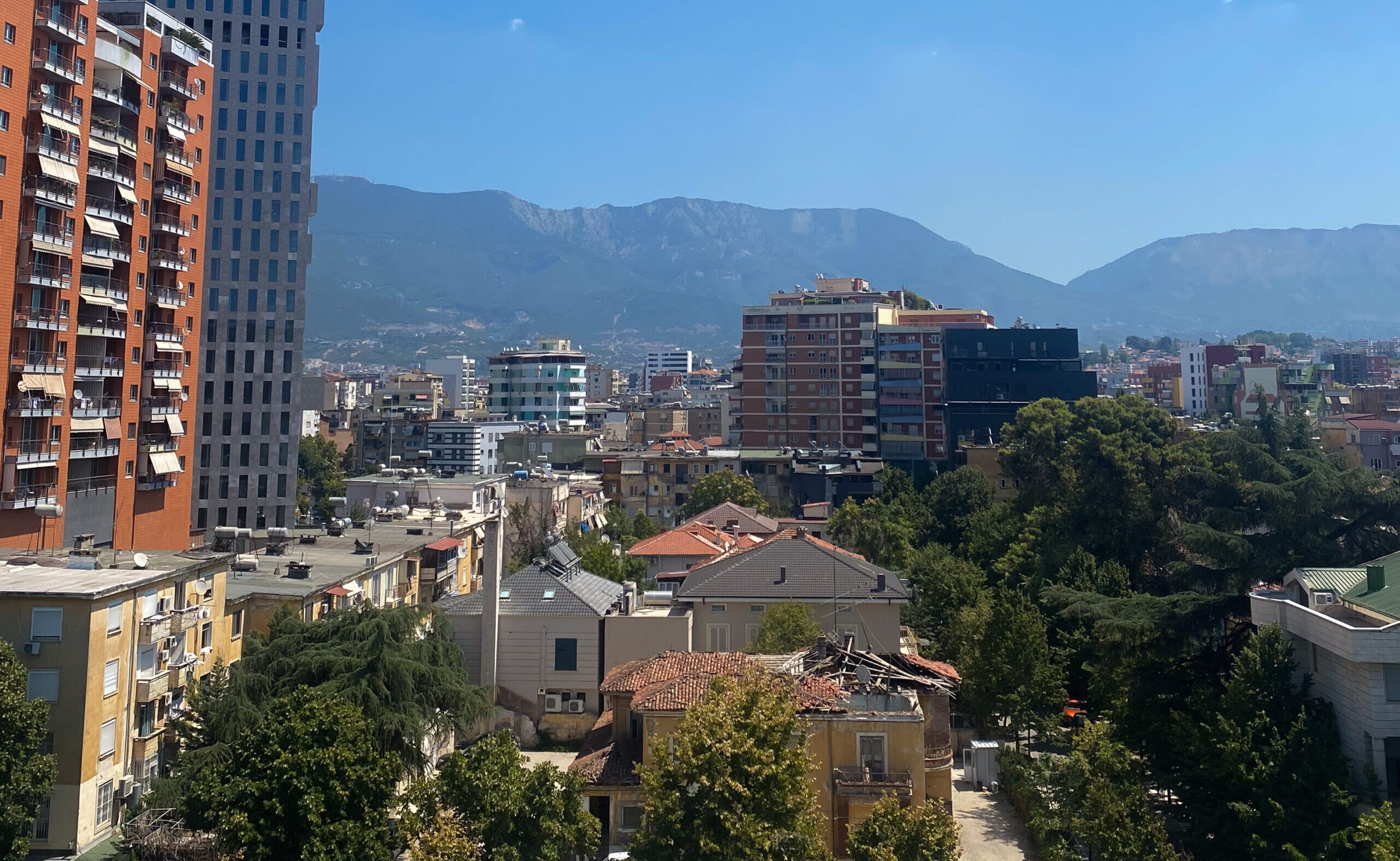 Views from the top of the Pyramid of Tirana showing the city of Tirana below with contrast between mountains and city.