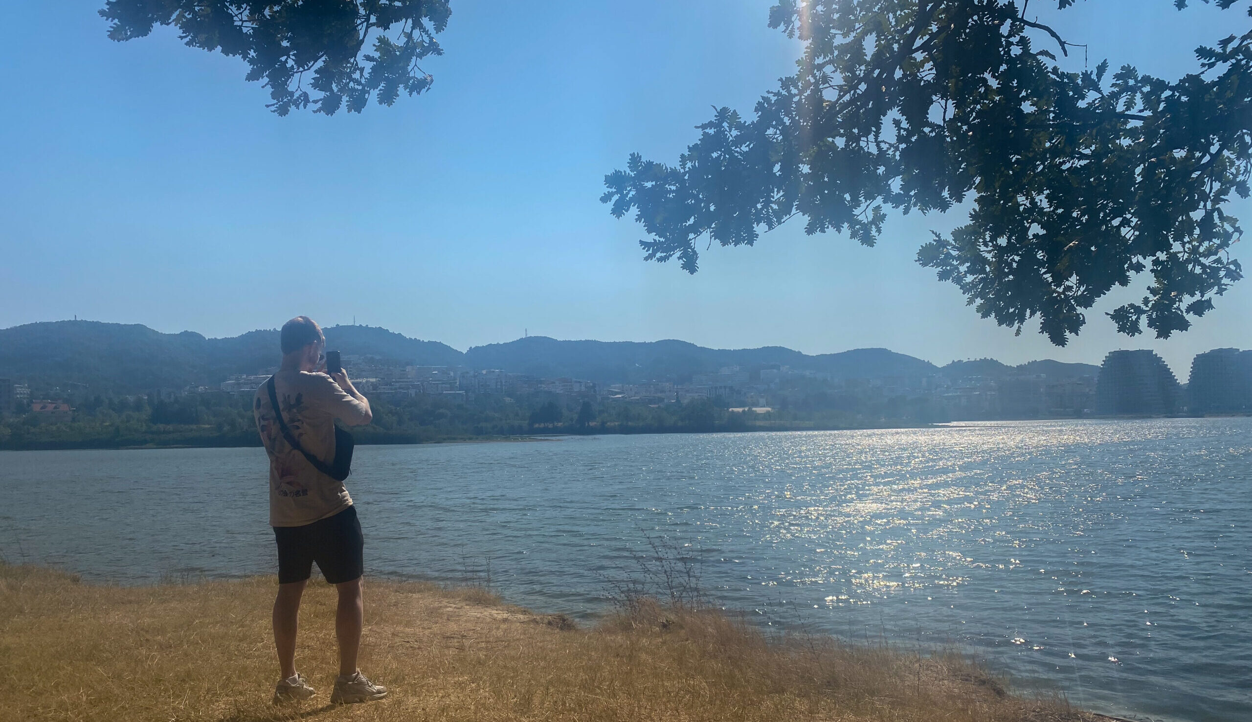 Standing at the edge of the gorgeous lake in the city at Tirana city park.