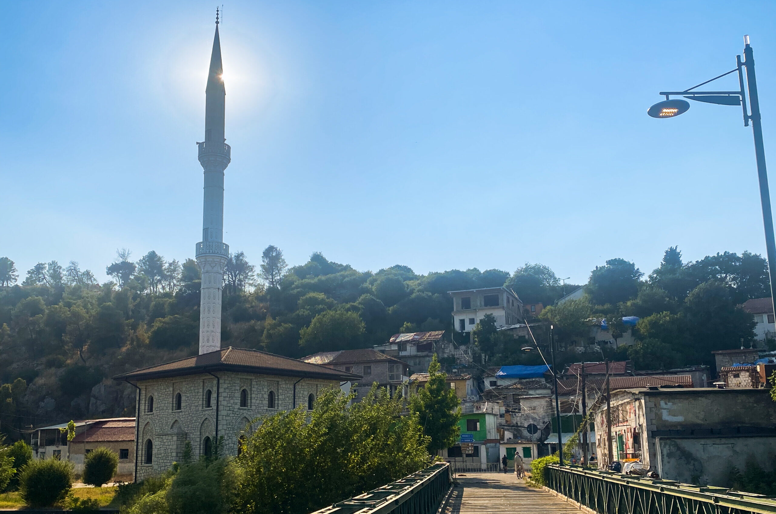 The bridge to the lakeside villages of Shkodra Lake with a minaret under the sun.