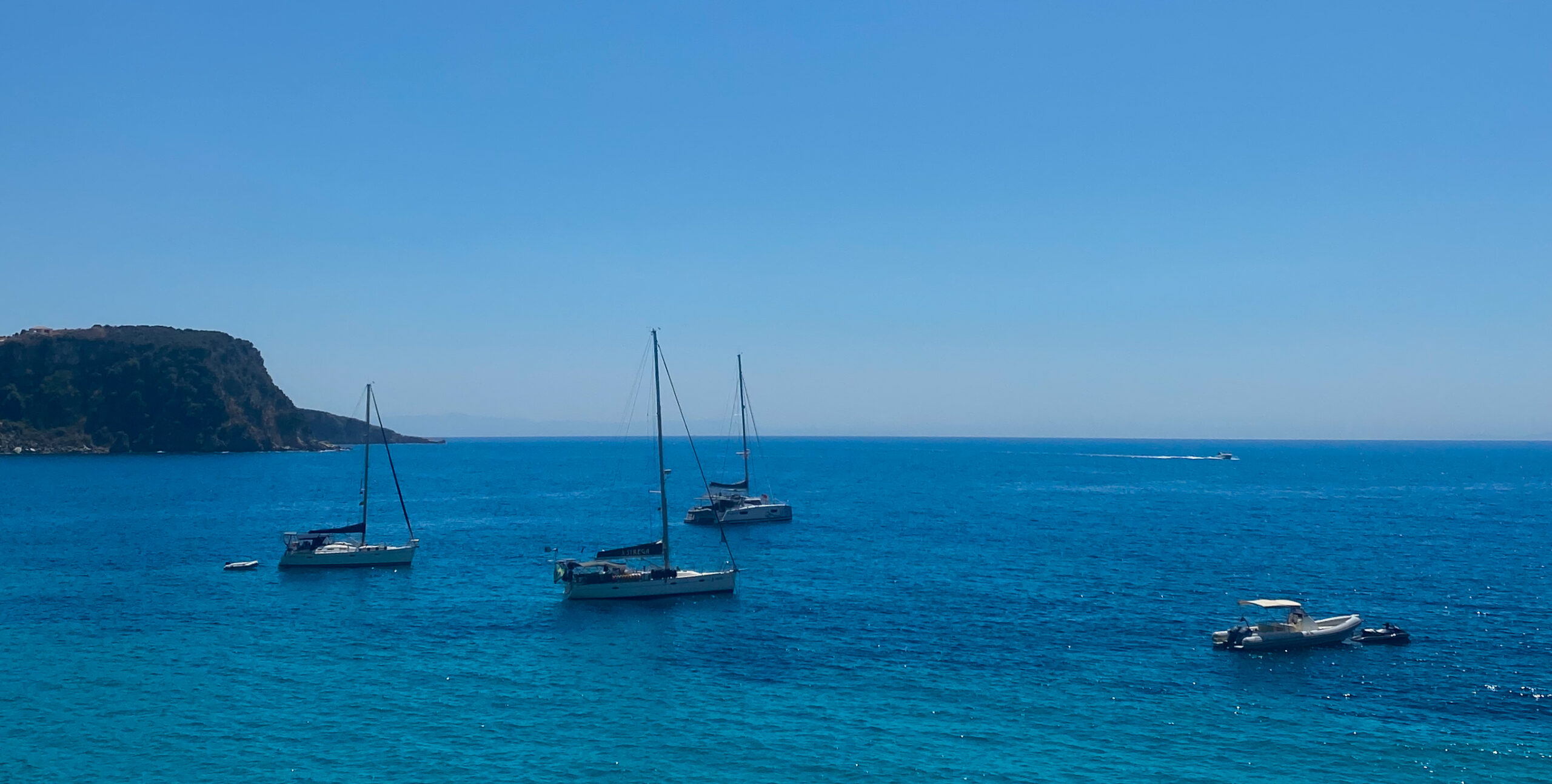 Insanely gorgeous waters on Himarë beach with clear blue water and sail boats