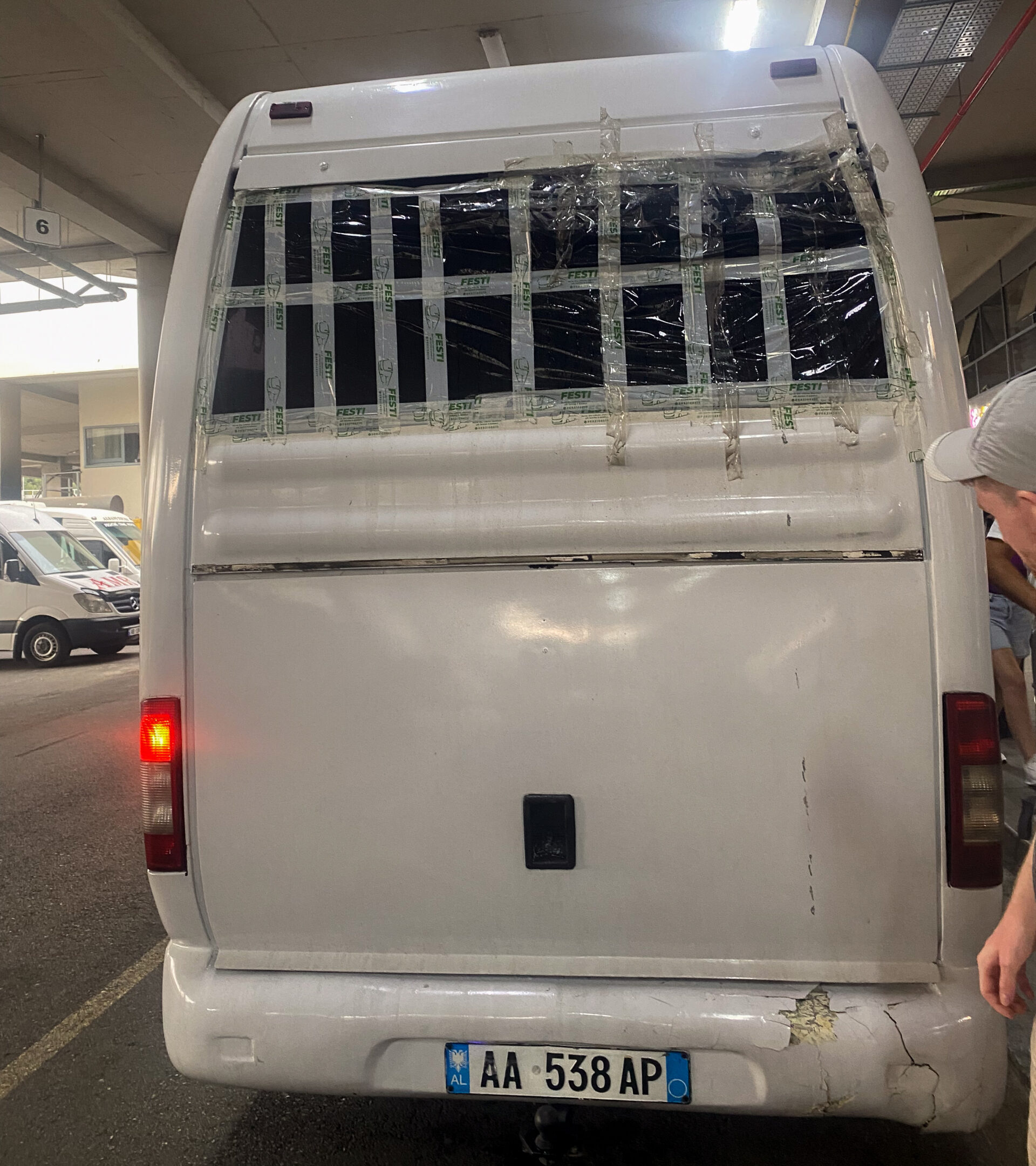 A furgon (minibus) for a journey from Korçë to Tirana where the back is sealed with tape and bin bags