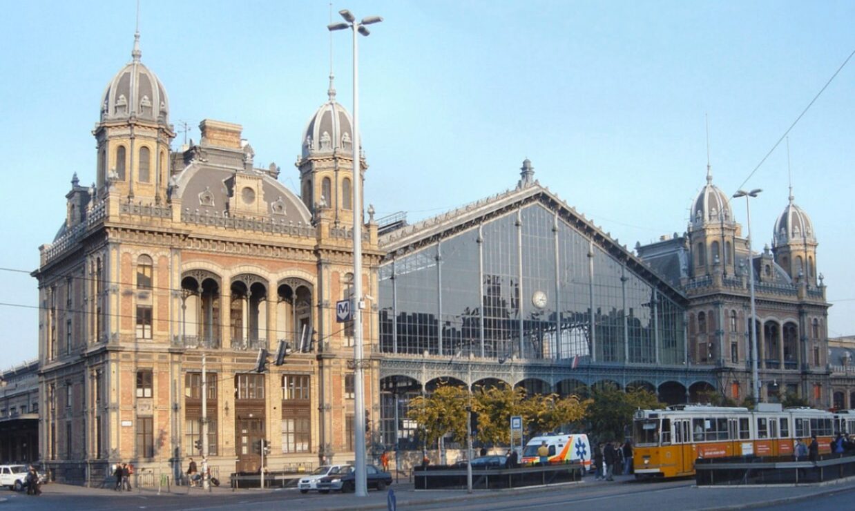 A grand train station in Budapest - known as the West Train Station, showcasing Hungarian architecture and their iconic yellow trams