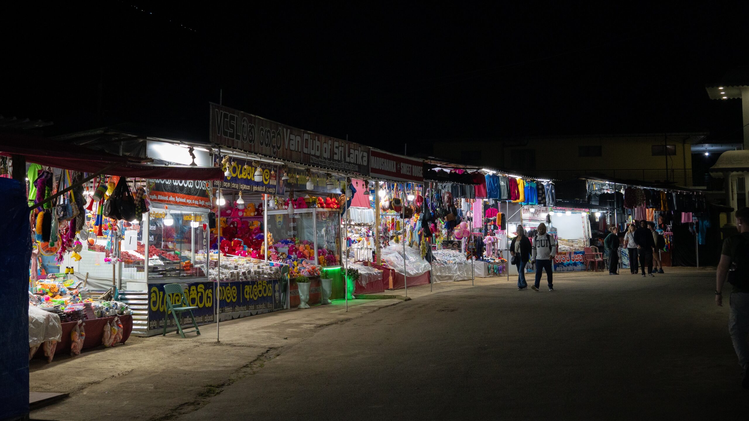 A night scene near Adam's Peak with open stalls selling toys, clothes, sweets and more