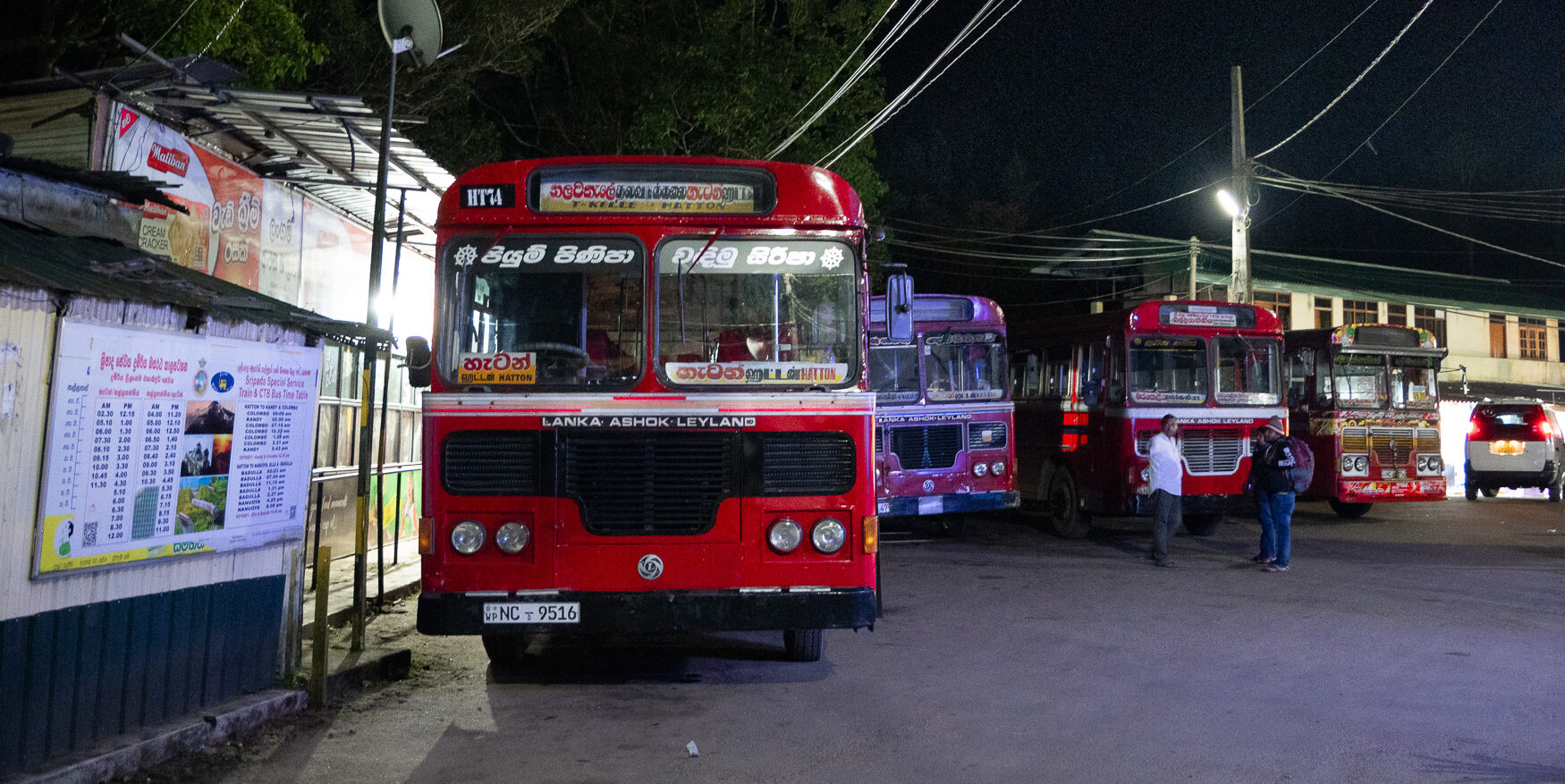 Red local Sri Lanka buses parked near Adam's Peak at night time