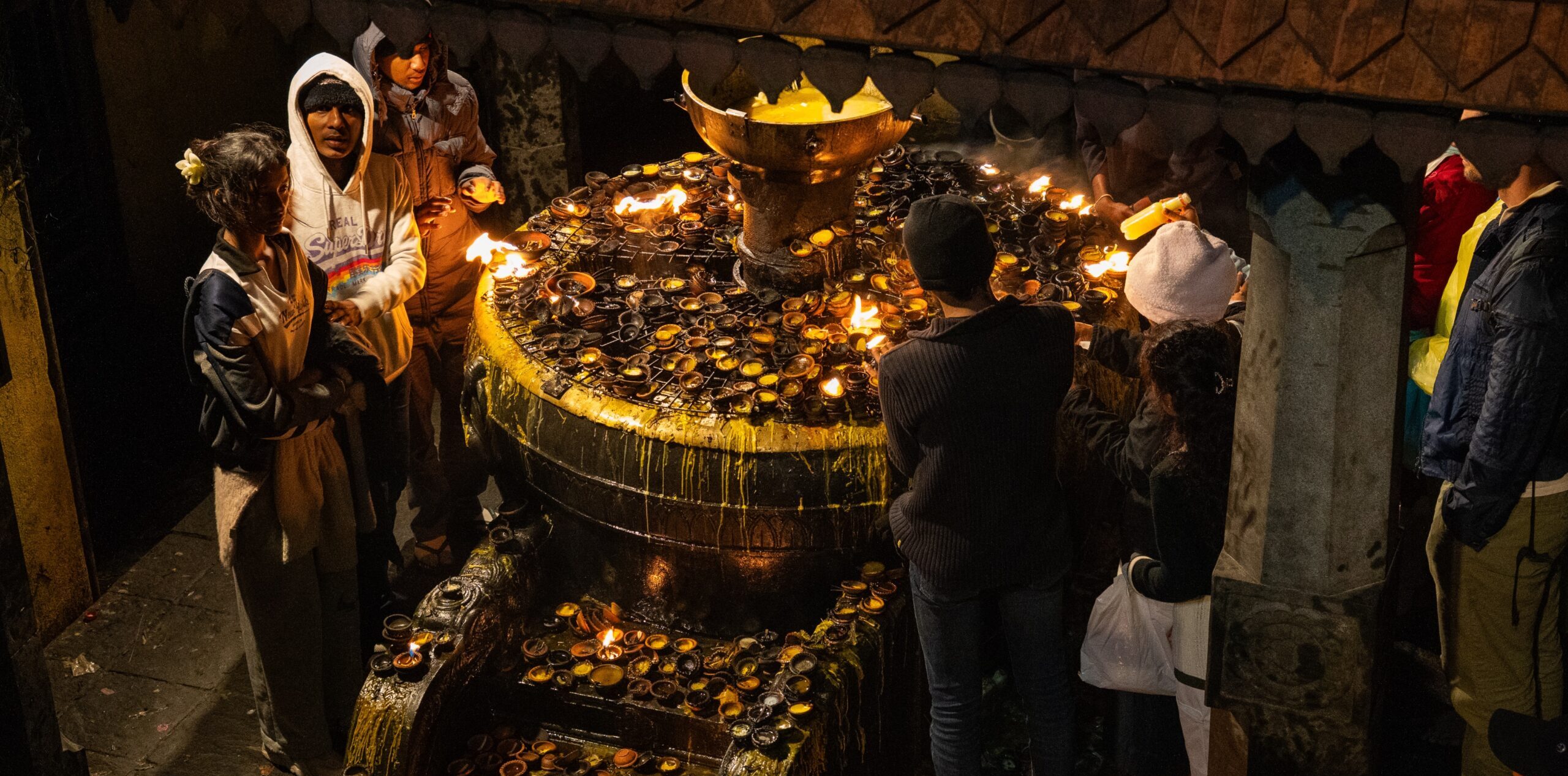 People lighting candles for wishes and devotion on top of Adam's Peak (Sri Pada) in Sri Lanka.