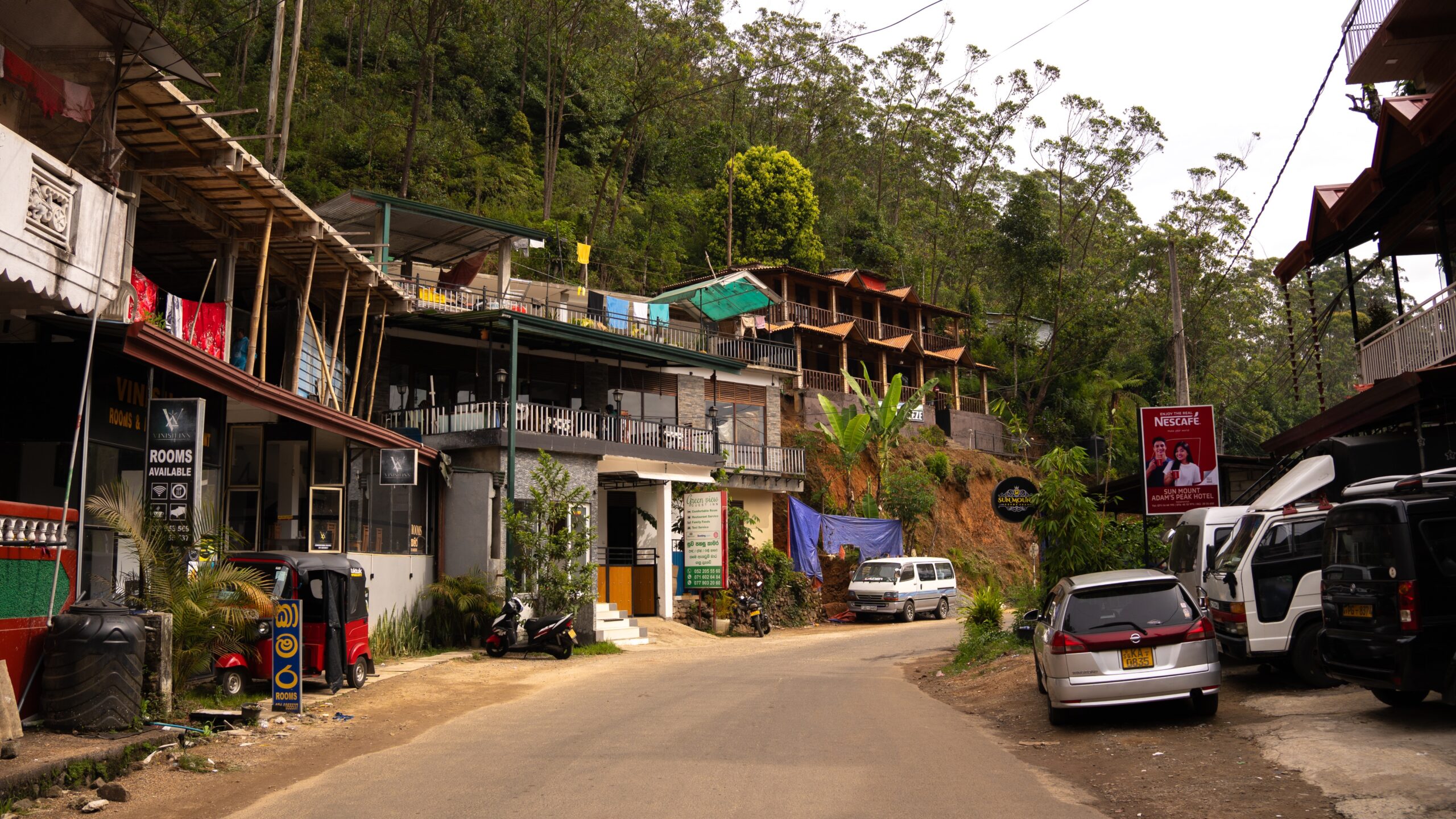 A main road near the Hatton Route entrance of Adam's Peak (Sri Pada) with shops, restaurants and hotels along the edge.