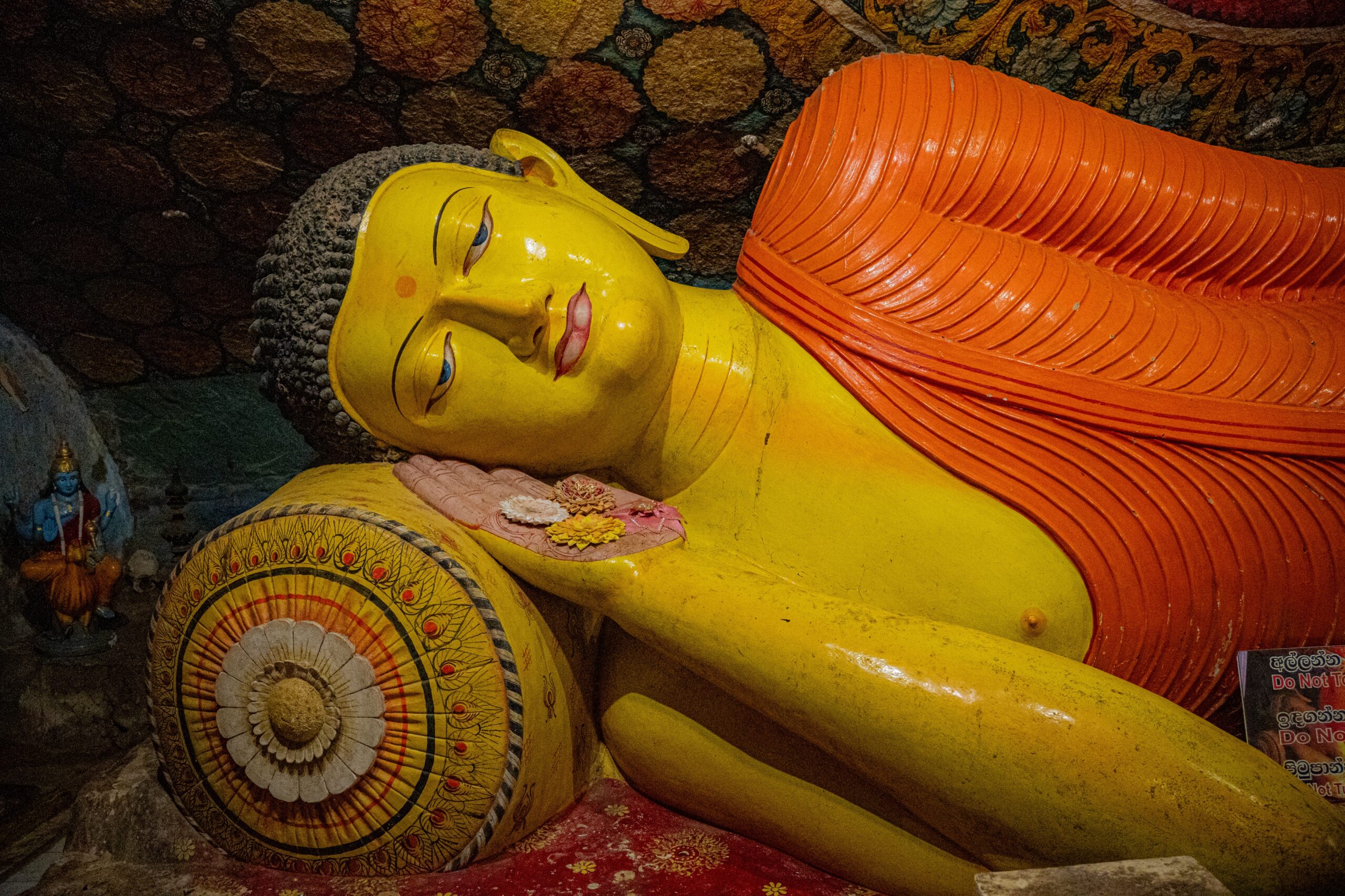 A laying down, sleeping buddha statue located at the base of Pidurangala Rock