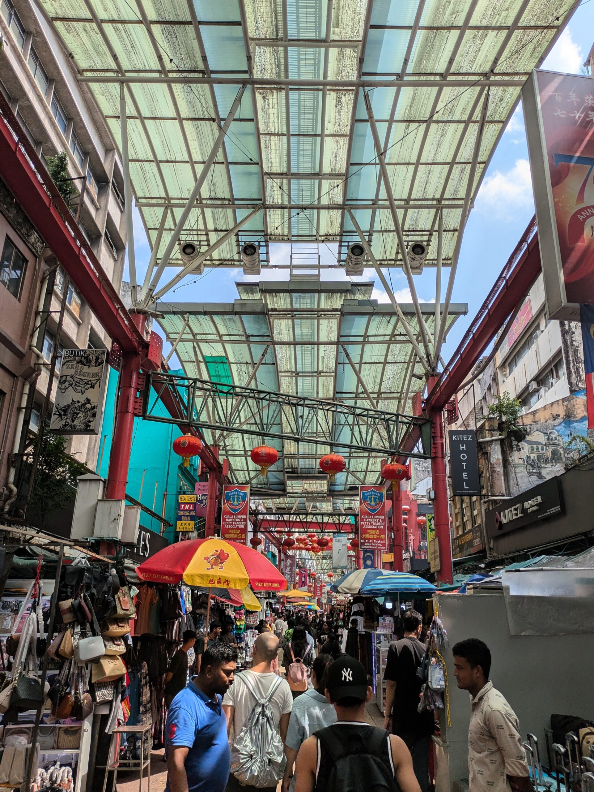 A busy indoor market area with people selling lots of different things in Kuala Lumpur