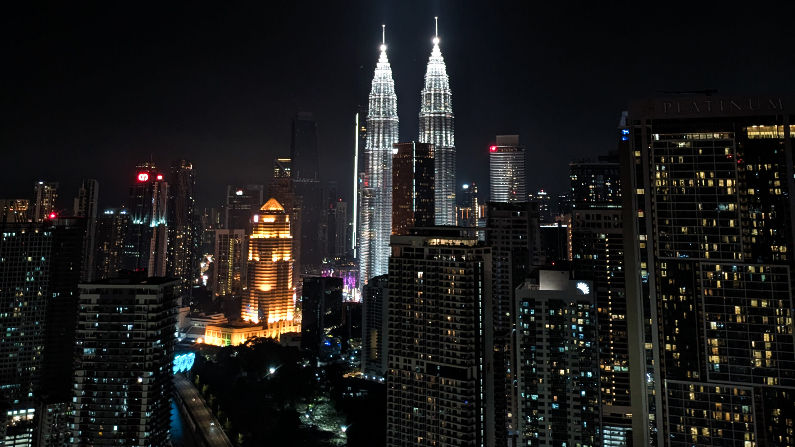 The iconic Petronas Twin Towers amongst the glowing skyline of Kuala Lumpur at night