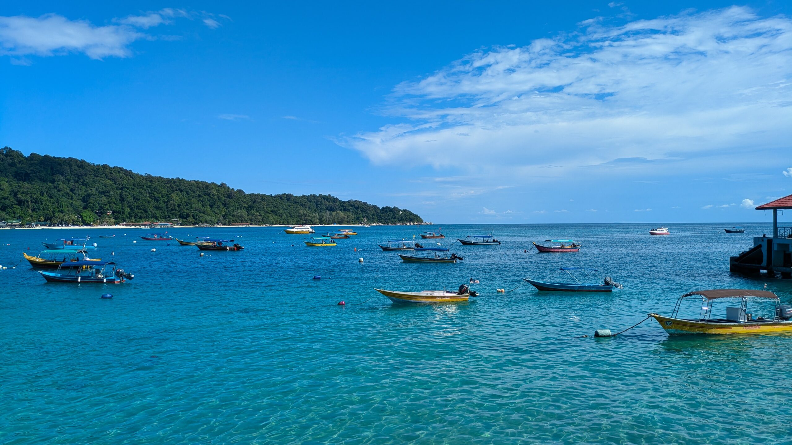 The crystal-clear blue waters around the Perhentian Islands with small boats