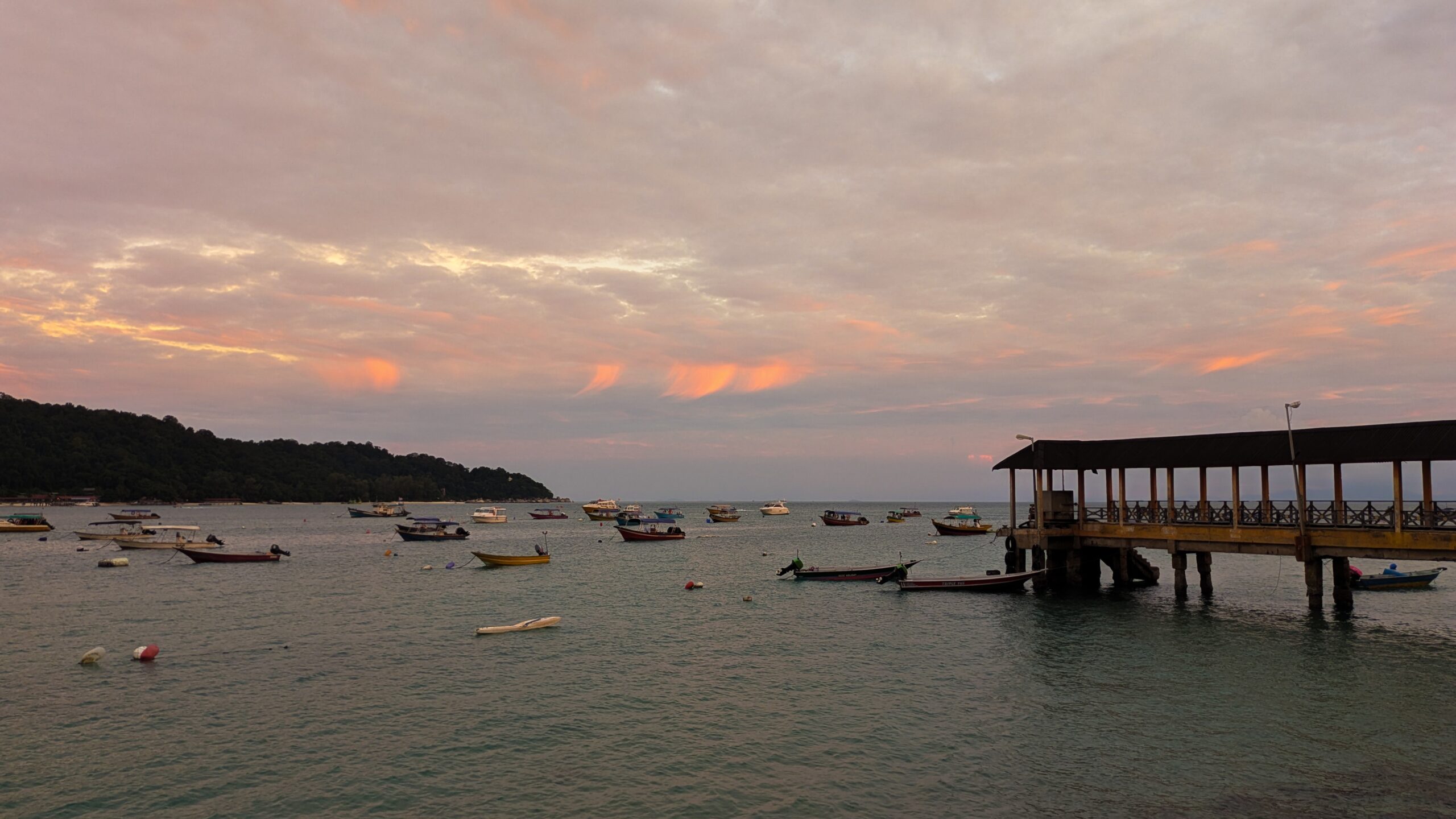 The cloudy sunset rolling in over the boats that sit on the shores of the Perhentian Islands, Malaysia