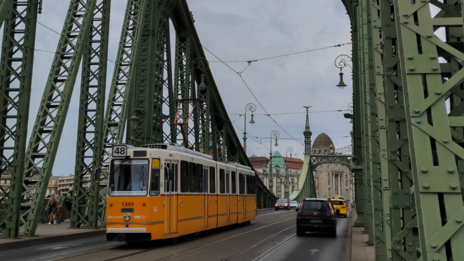 An iconic yellow tram going over the metal bridges of the Danube River in Budapest Hungary