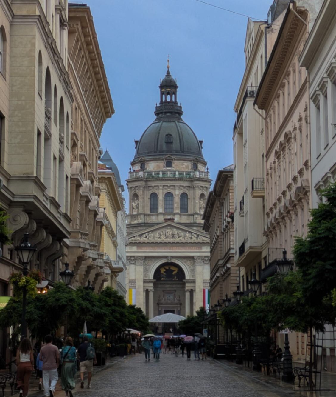 A gorgeous central view of the impress St. Stephen's Basilica with tourists exploring the city of Budapest