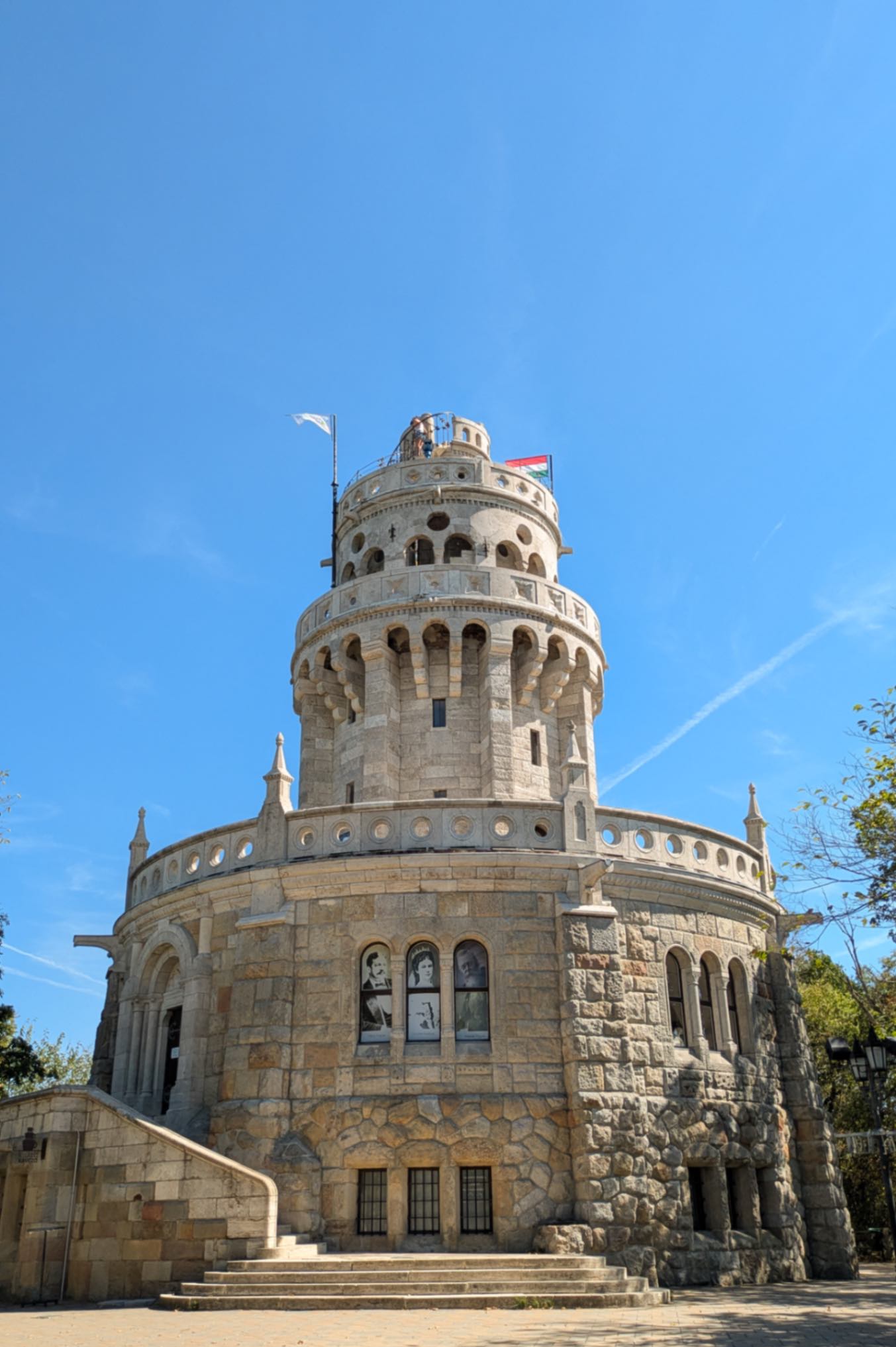 A huge tower, with European architecture, royal figures on the front and blue skies