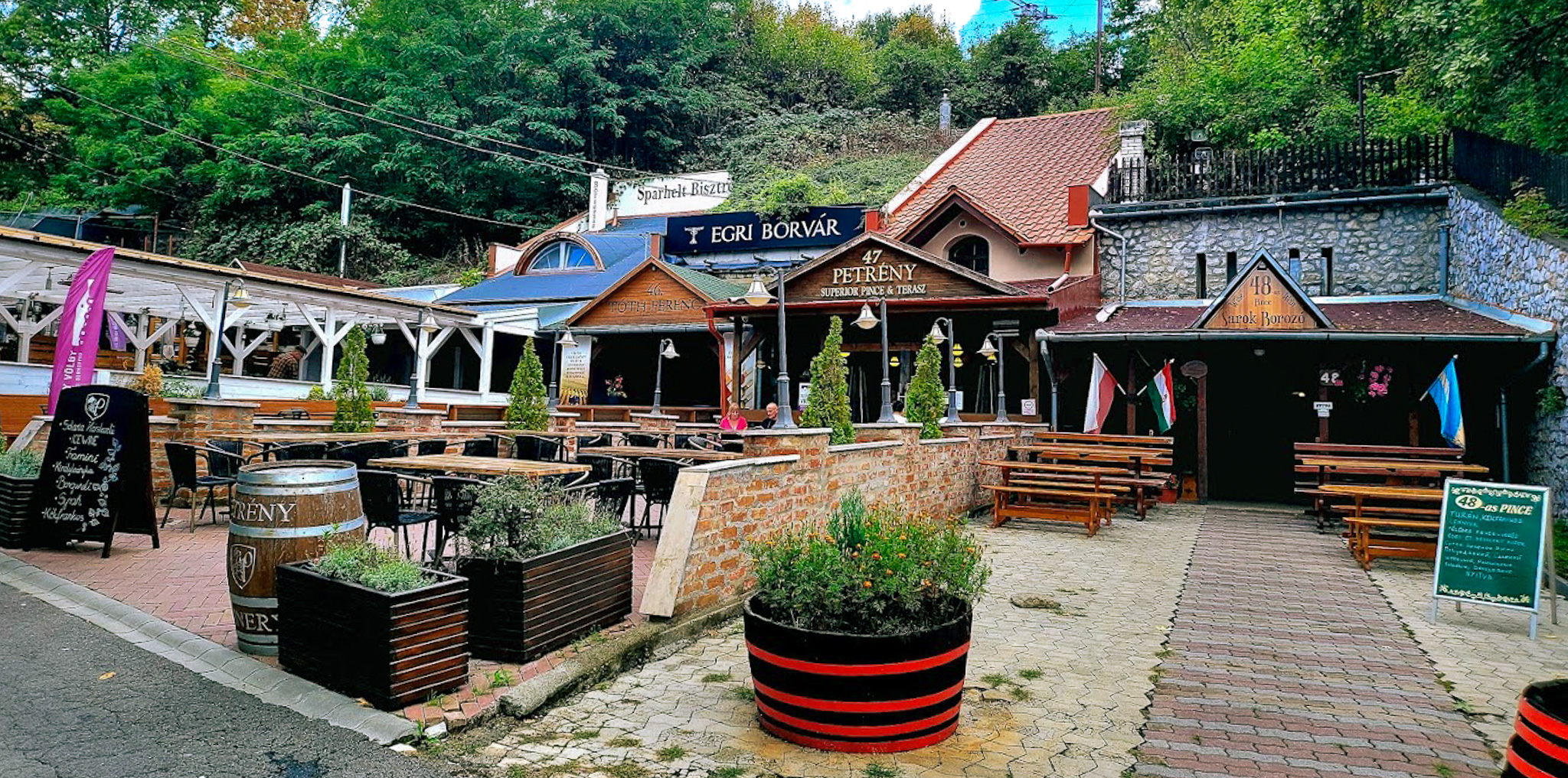 A row of wine cellars made out of the caves behind them