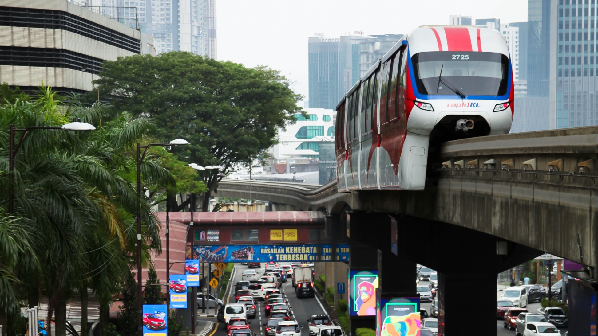 The Kuala Lumpur monorail approaching the station with busy city traffic below