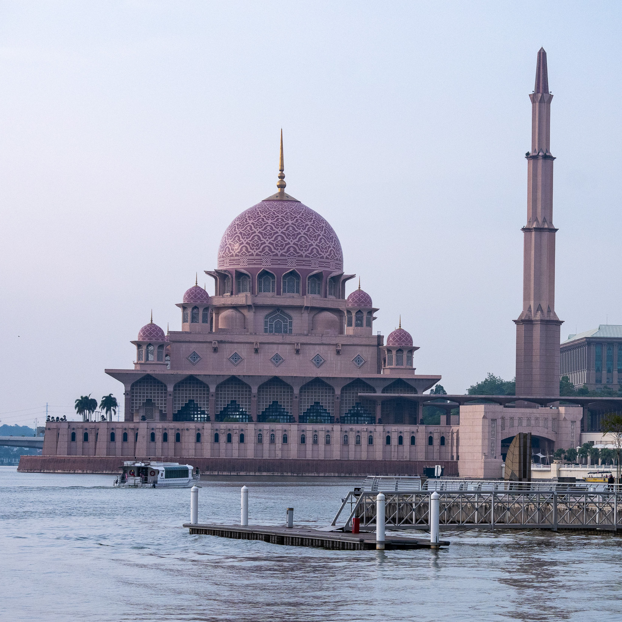 A vibrant pink mosque sat on the water near to Putrajaya, Kuala Lumpur, Malaysia