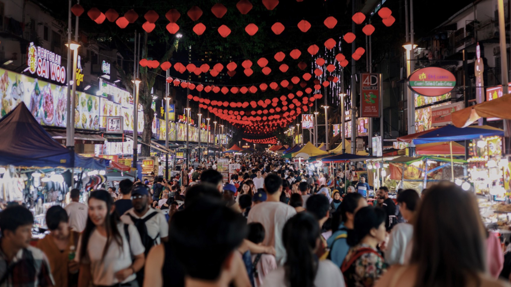 A night scene in busy Kuala Lumpur with lots of food stalls and Chinese lanterns