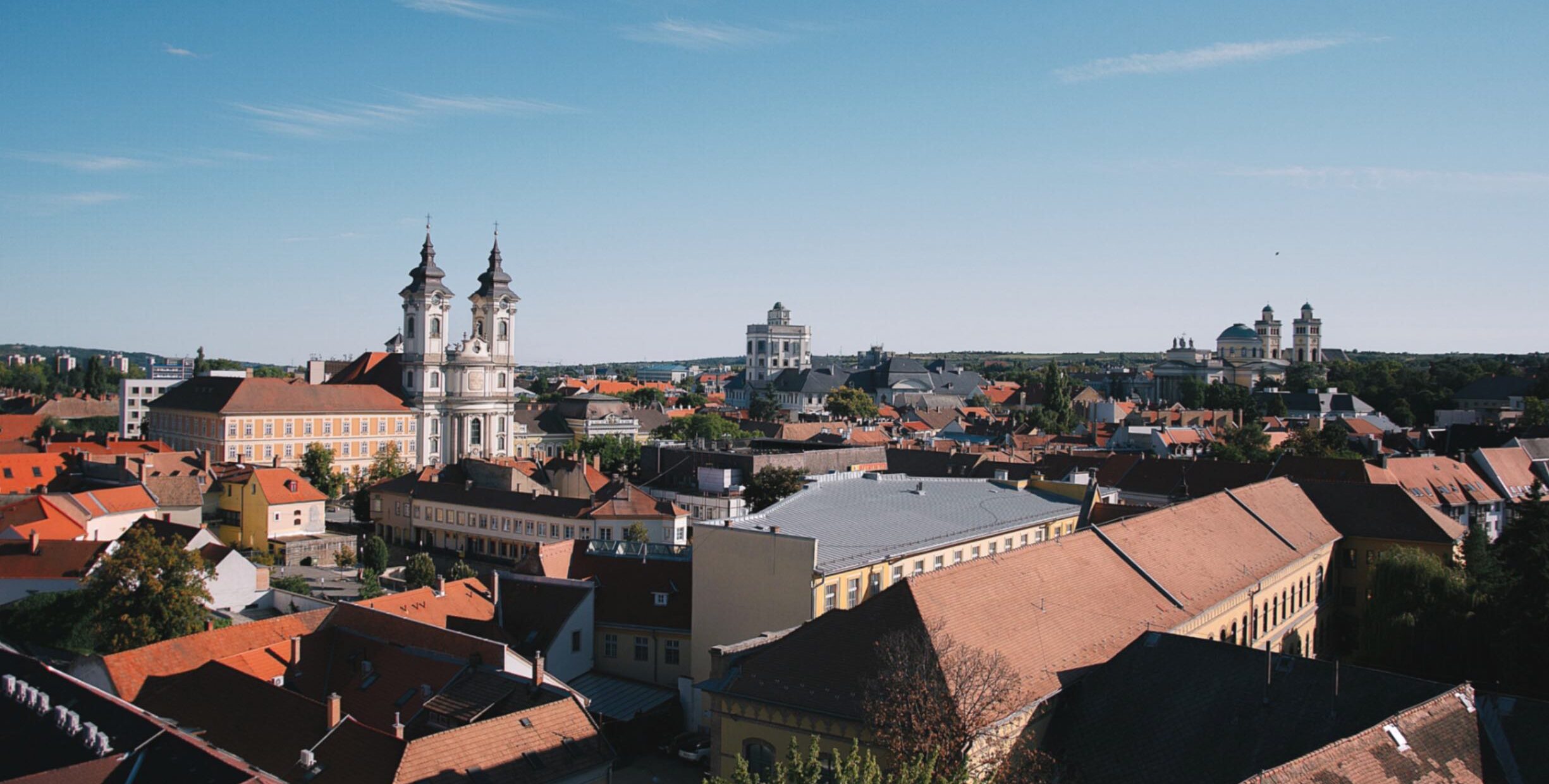 A shot of Eger city from a high point, showcasing its churches as well as regular houses, shops and restaurants