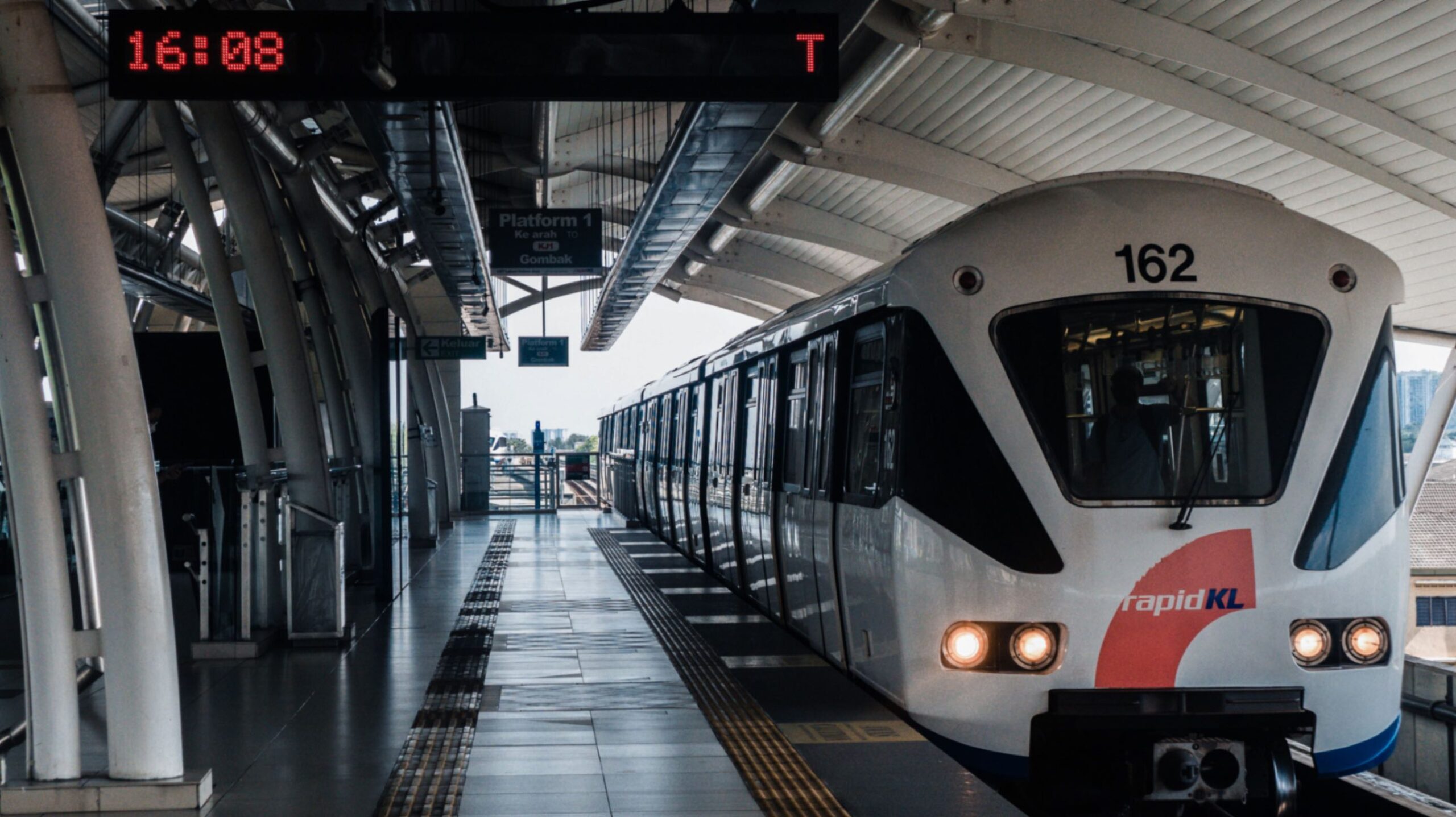 A Malaysian train pulling up at the station with an empty platform