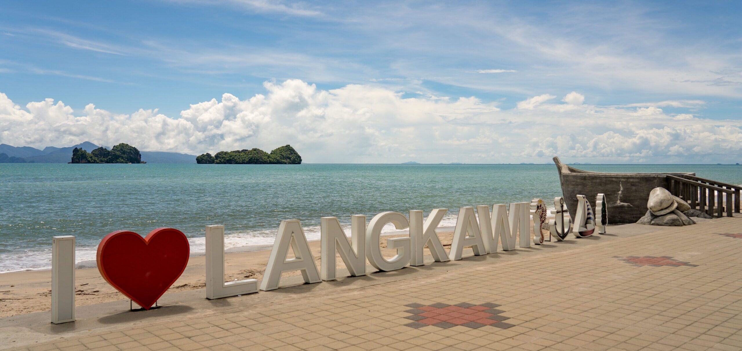 The I love langkawi sign right on the coast with blue skies and pretty waters