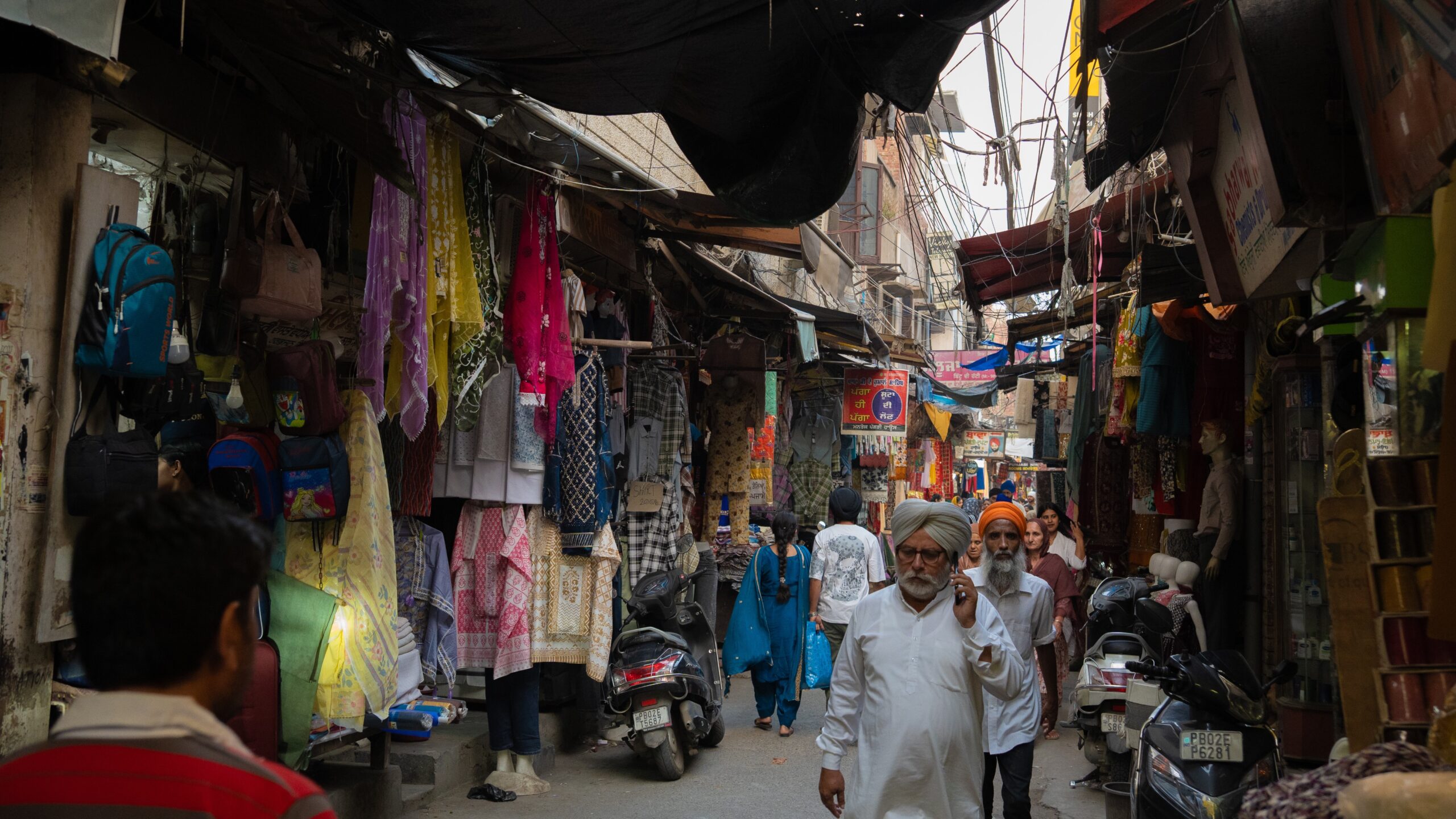 Bustling streets of Amritsar, filled with local Sikh people walking through and clothes being sold