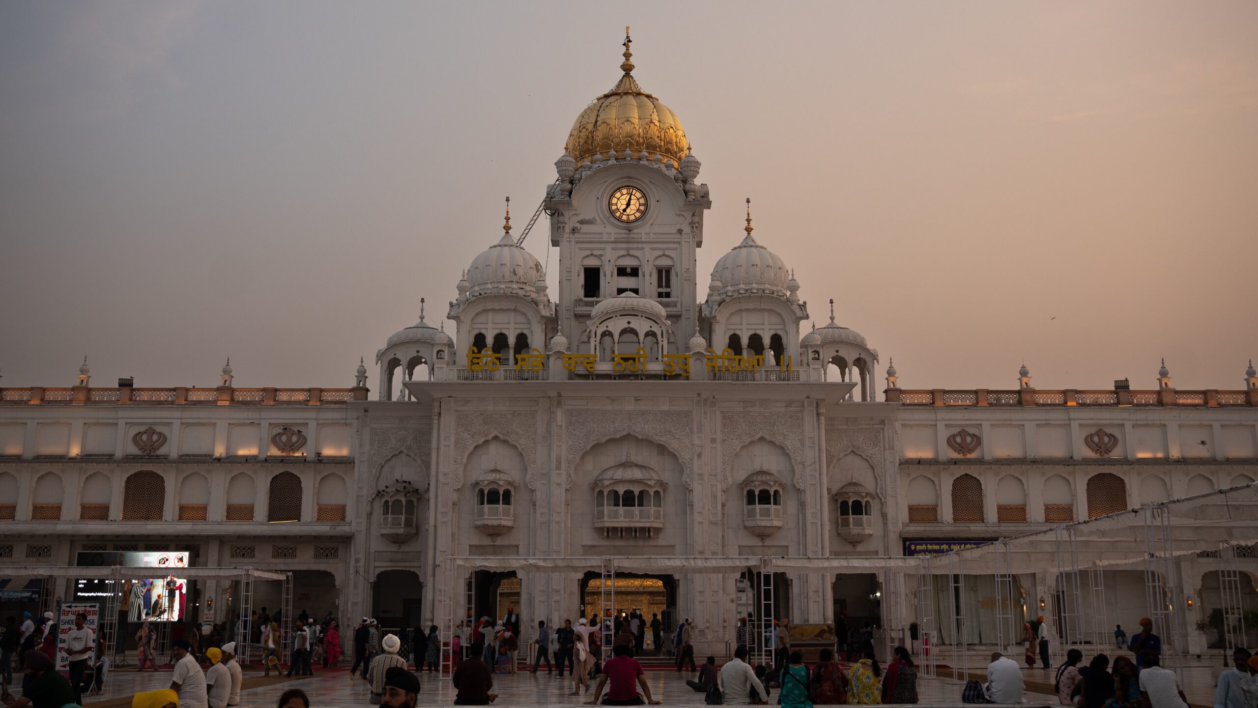 The outside of the Golden Temple as the sun starts to set and the sky starts turning orange