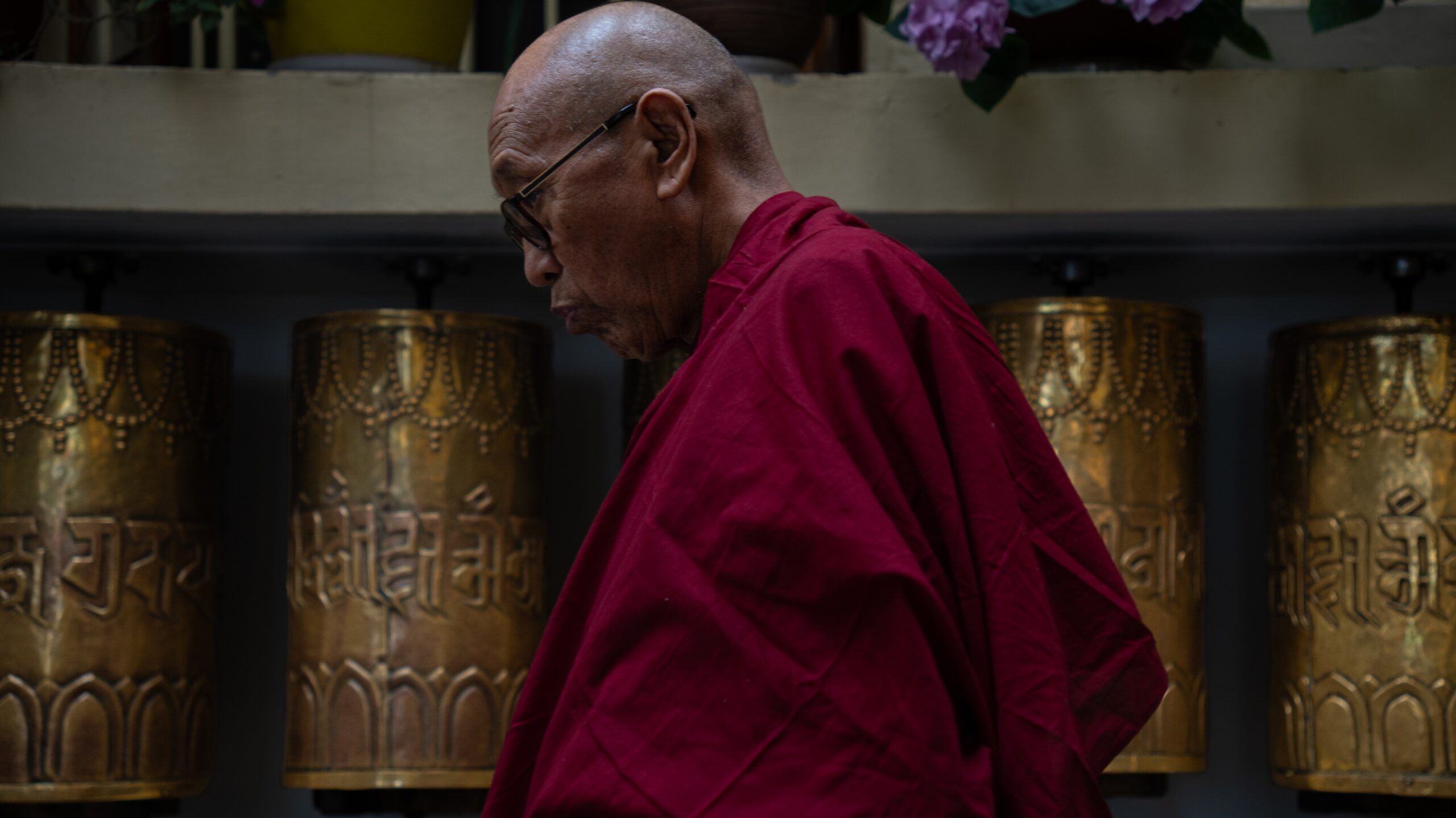A buddhist monk taking a walk around the buddhist prayer wheels at the temple complex