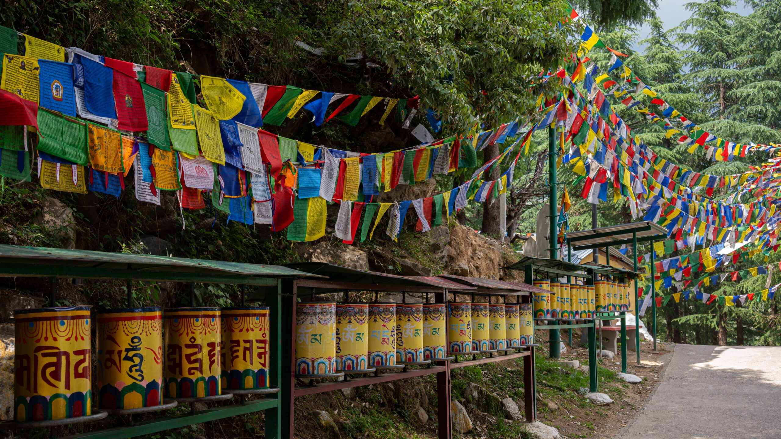 Buddhist prayer wheels and Tibetan Buddhist flags flying around a temple.