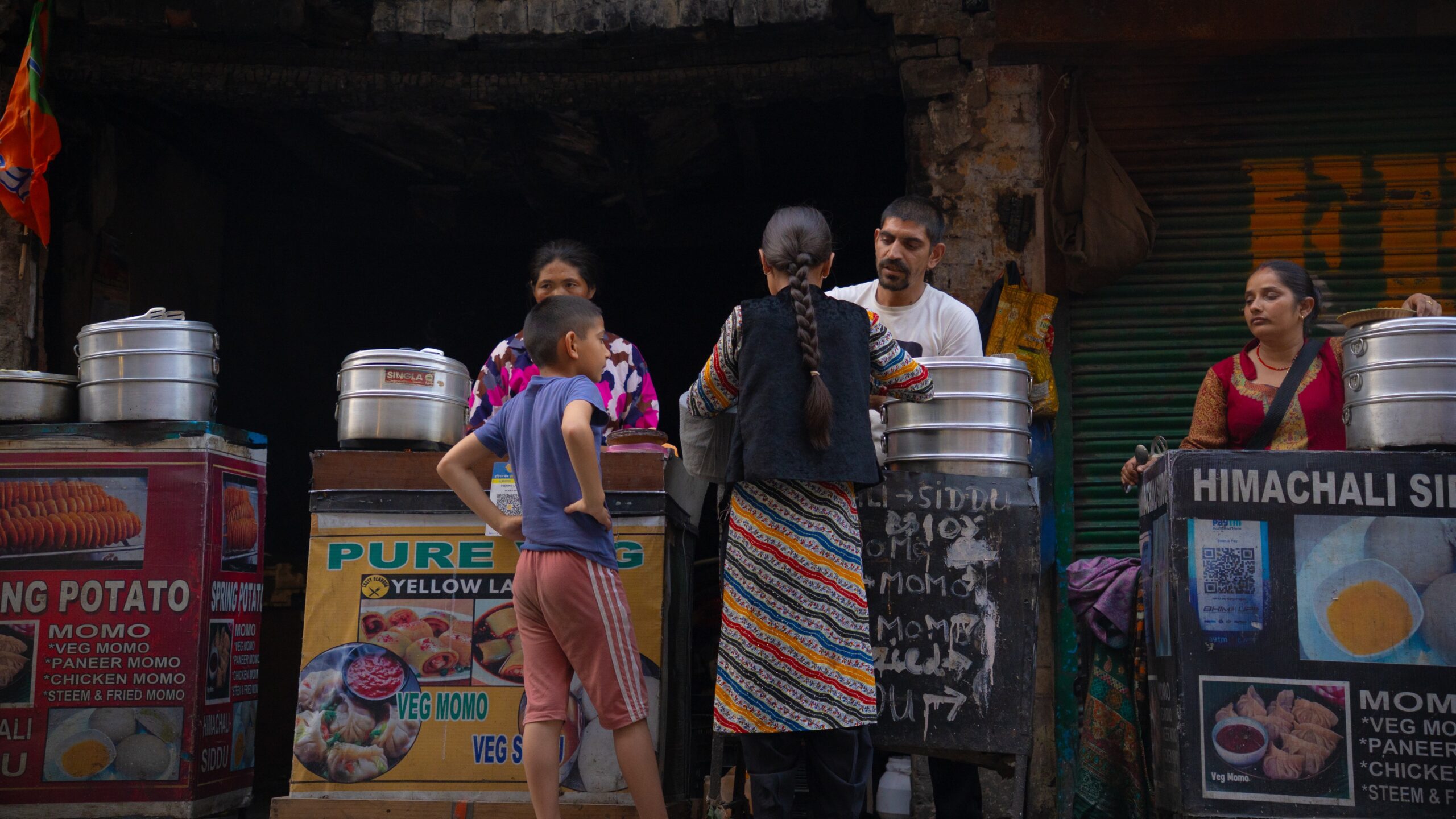 Two children outside of street food stalls in Mini Tibet - McLeod Ganj, Dharamshala