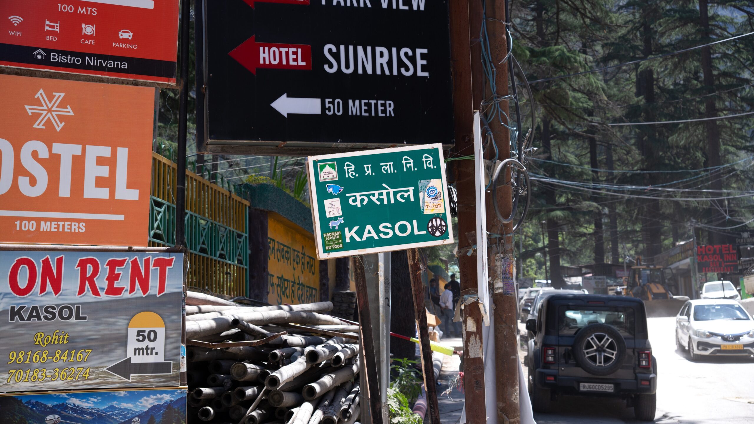 Lots of signs with one in the centre reading Kasol, a small town in Himachal Pradesh