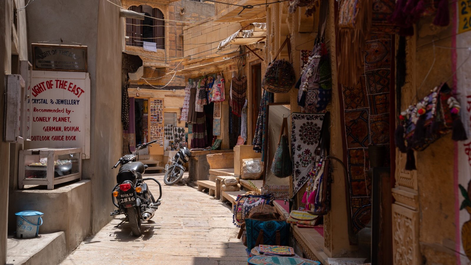 A sandstone, desert street in a settlement, featuring shops of Jaisalmer Fort