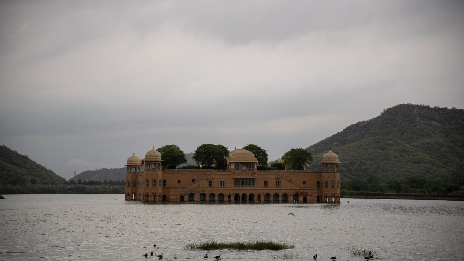 A palace floating on a body of water with a grey sky above