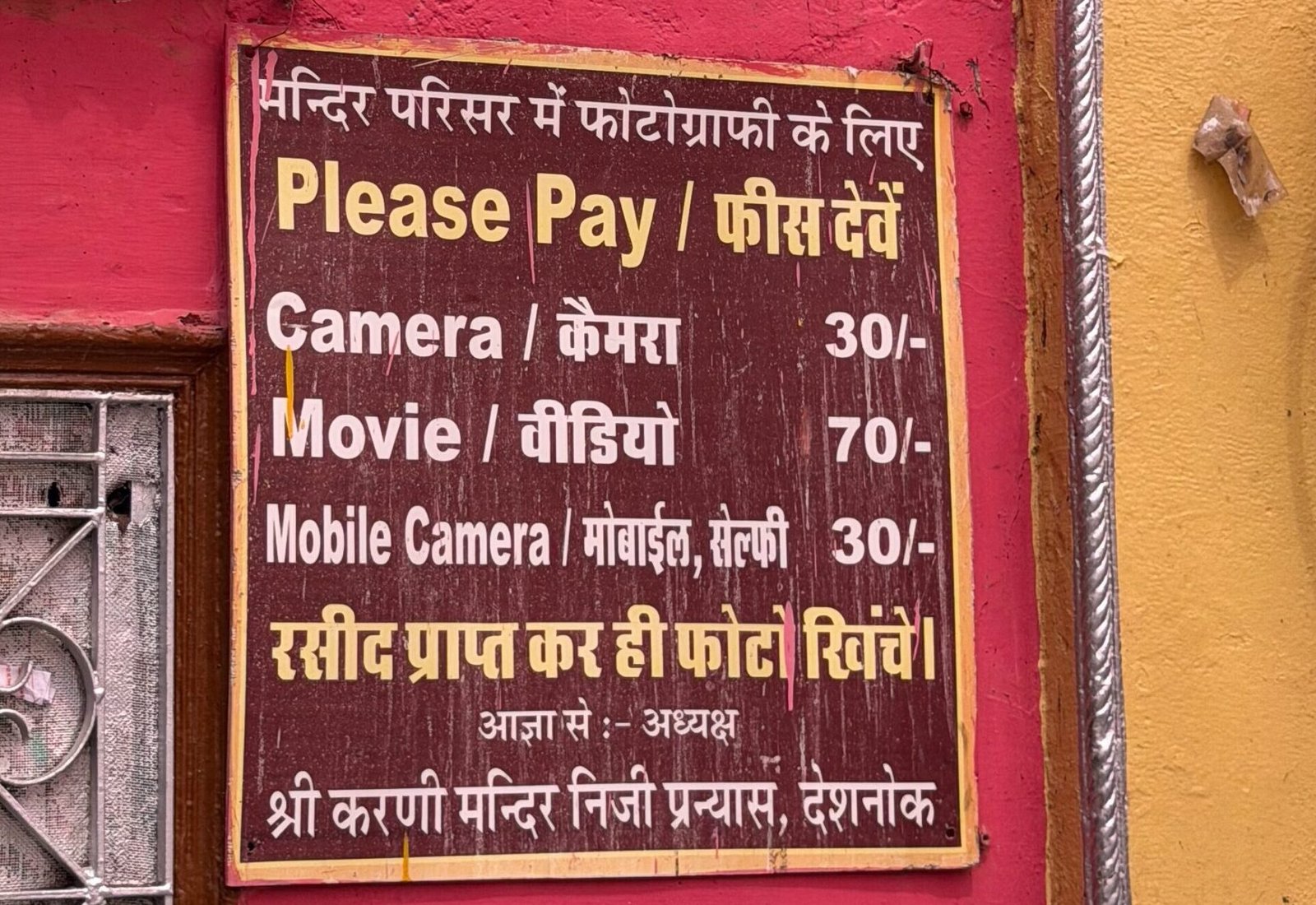 A sign inside the Rat Temple displaying prices for taking photos
