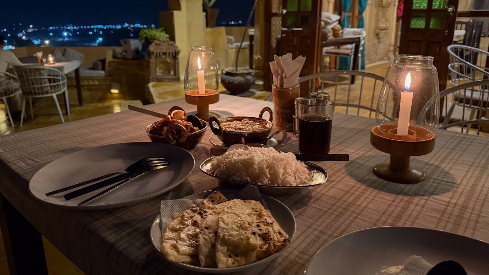 A candlelit dinner in Jaisalmer on a rooftop restaurant inside the fort - featuring a curry and rice