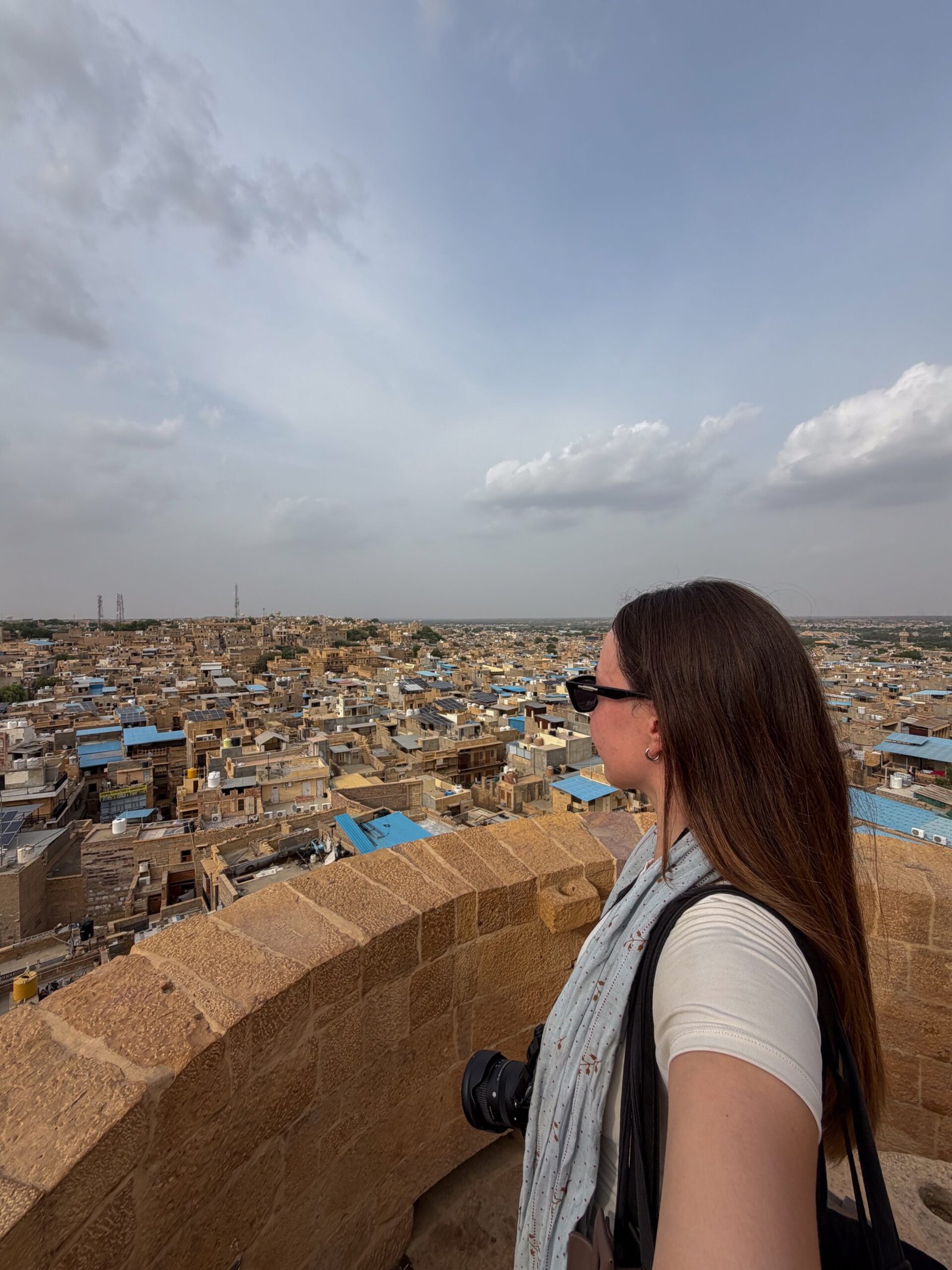 A women looking out over a city and desert landscape below