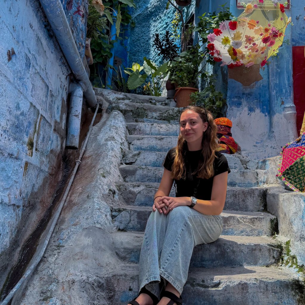 A women sat on a set of stairs in a Blue painted area of Jodhpur - known as the Blue City of India
