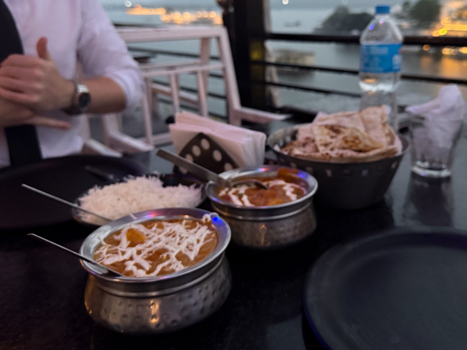 A traditional curry, rice, naan set up in India at a restaurant in Udaipur overlooking the lake