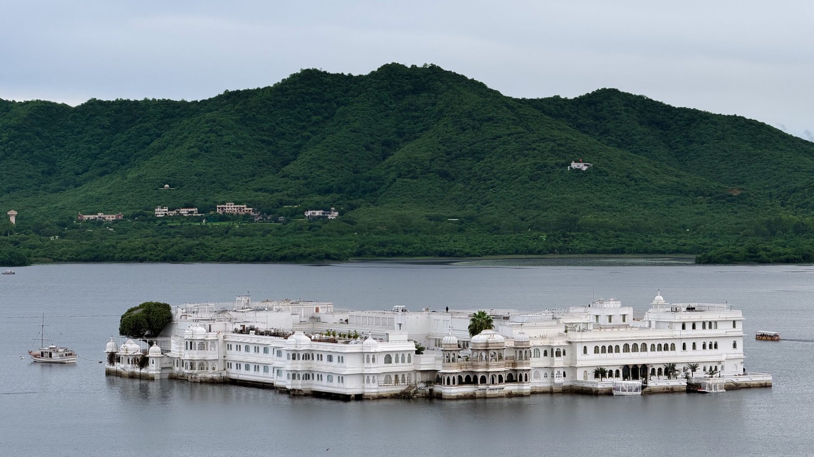 The huge Taj Palace hotel in Udaipur that sits on the large lake with the green hills behind it