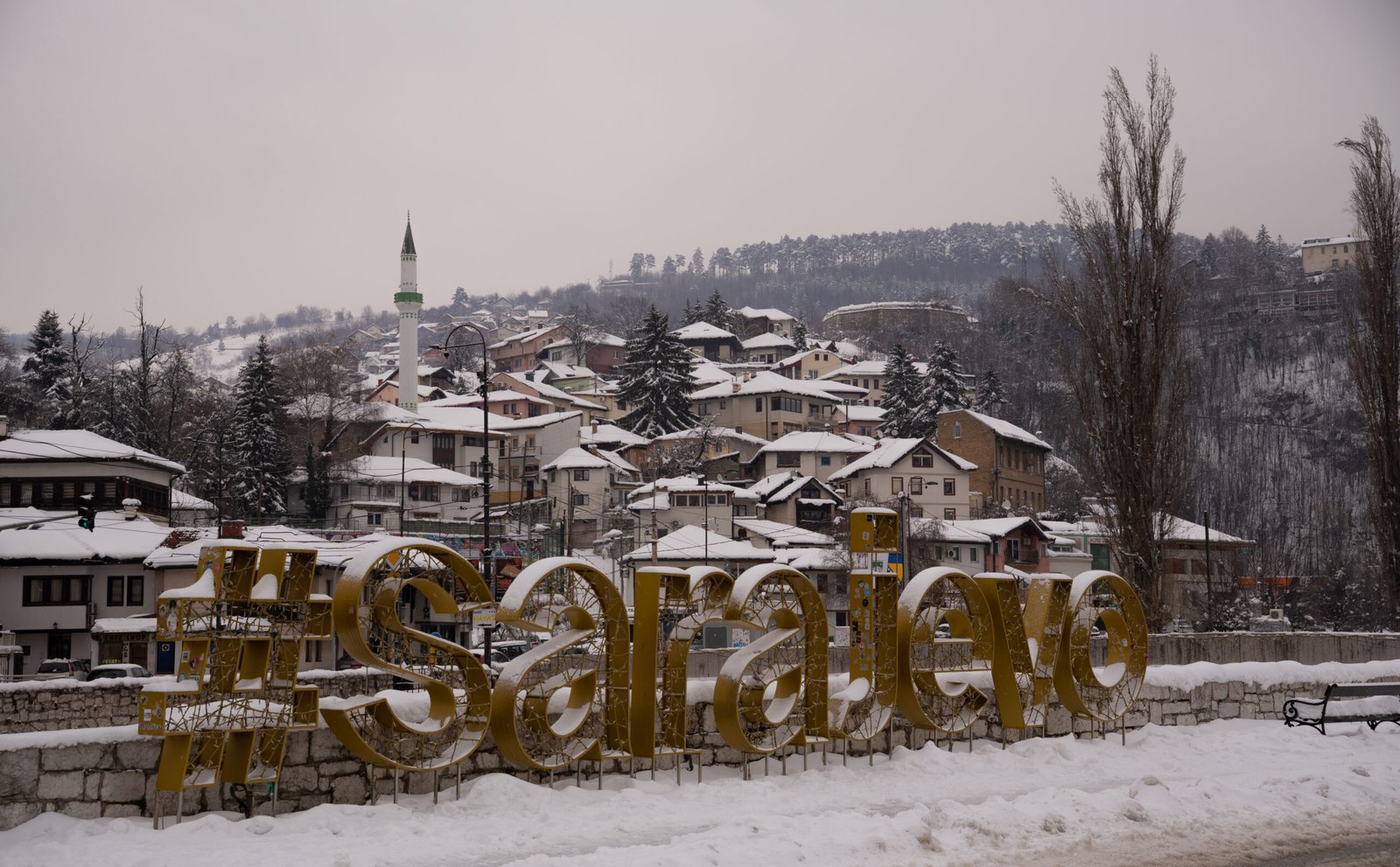 A snowy landscape with houses and signage reading "Sarajevo" - a perfect start for Sarajevo travel guide
