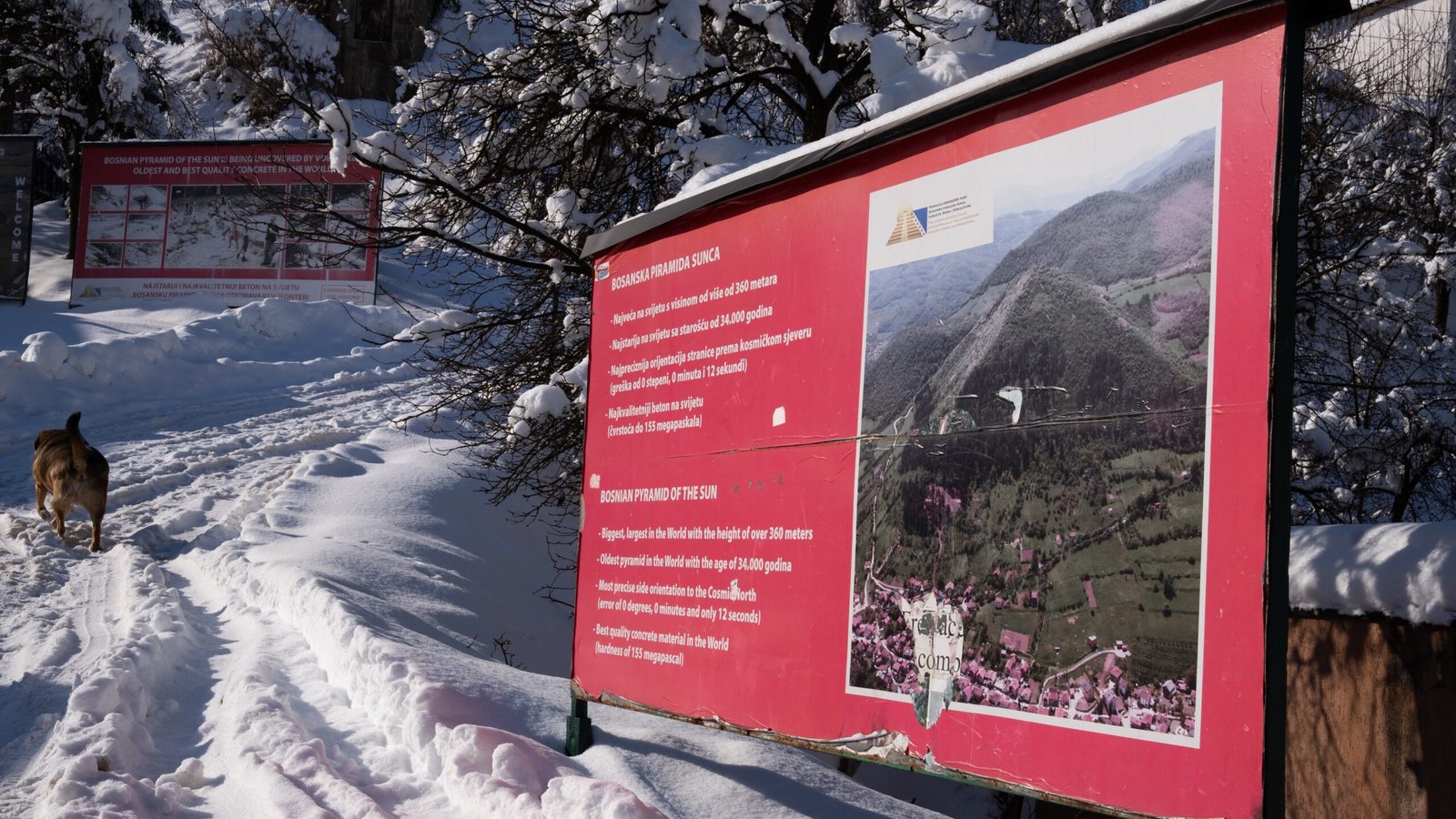 A red sign pointing up to the Pyrmaids of the Sun - the Bosnian Pyramids in the snow