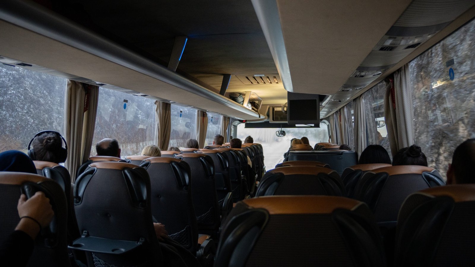 The inside of a bus with leather seats and a snowy outside