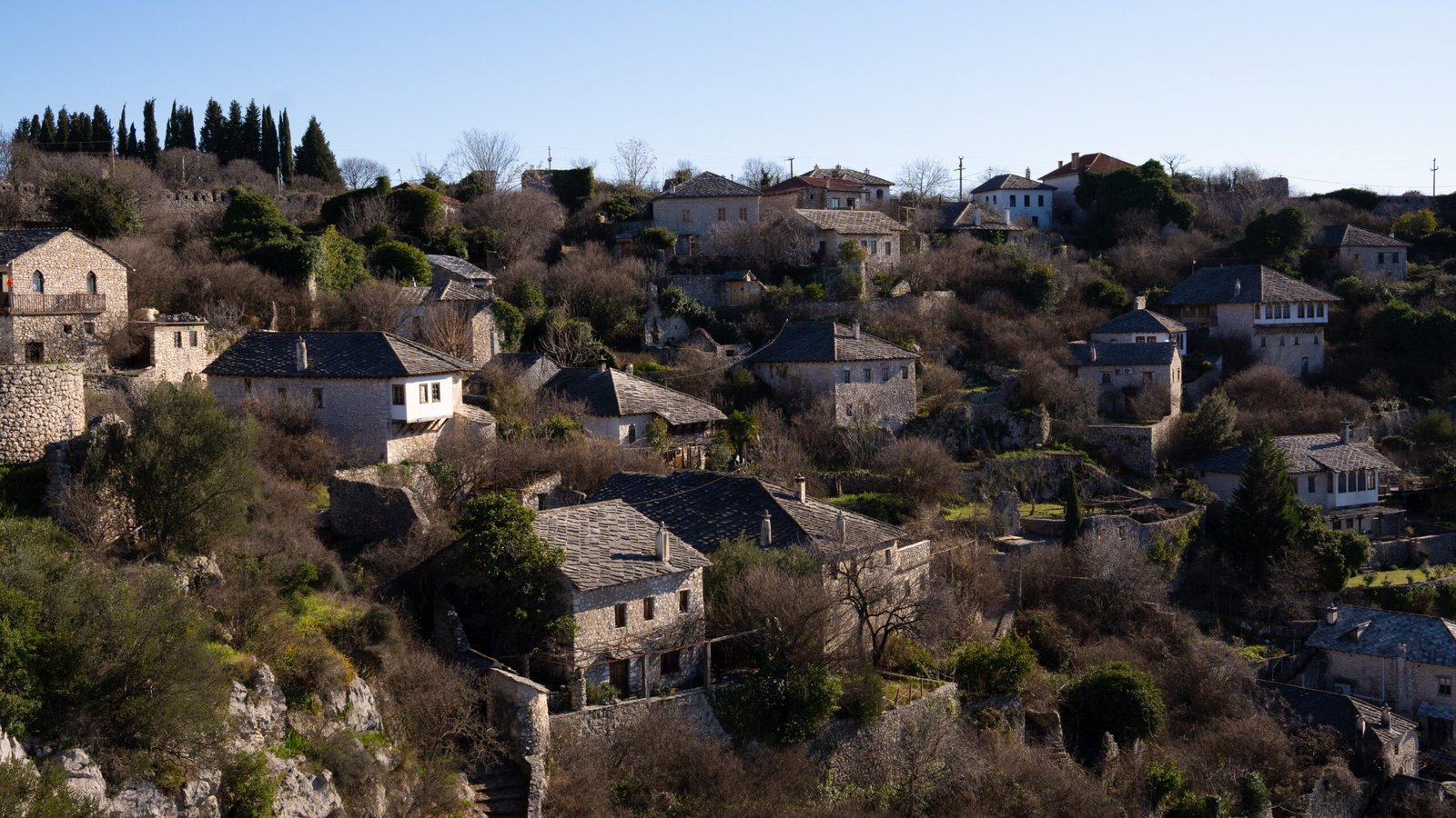Homes and buildings perched on a hill with blue skies above