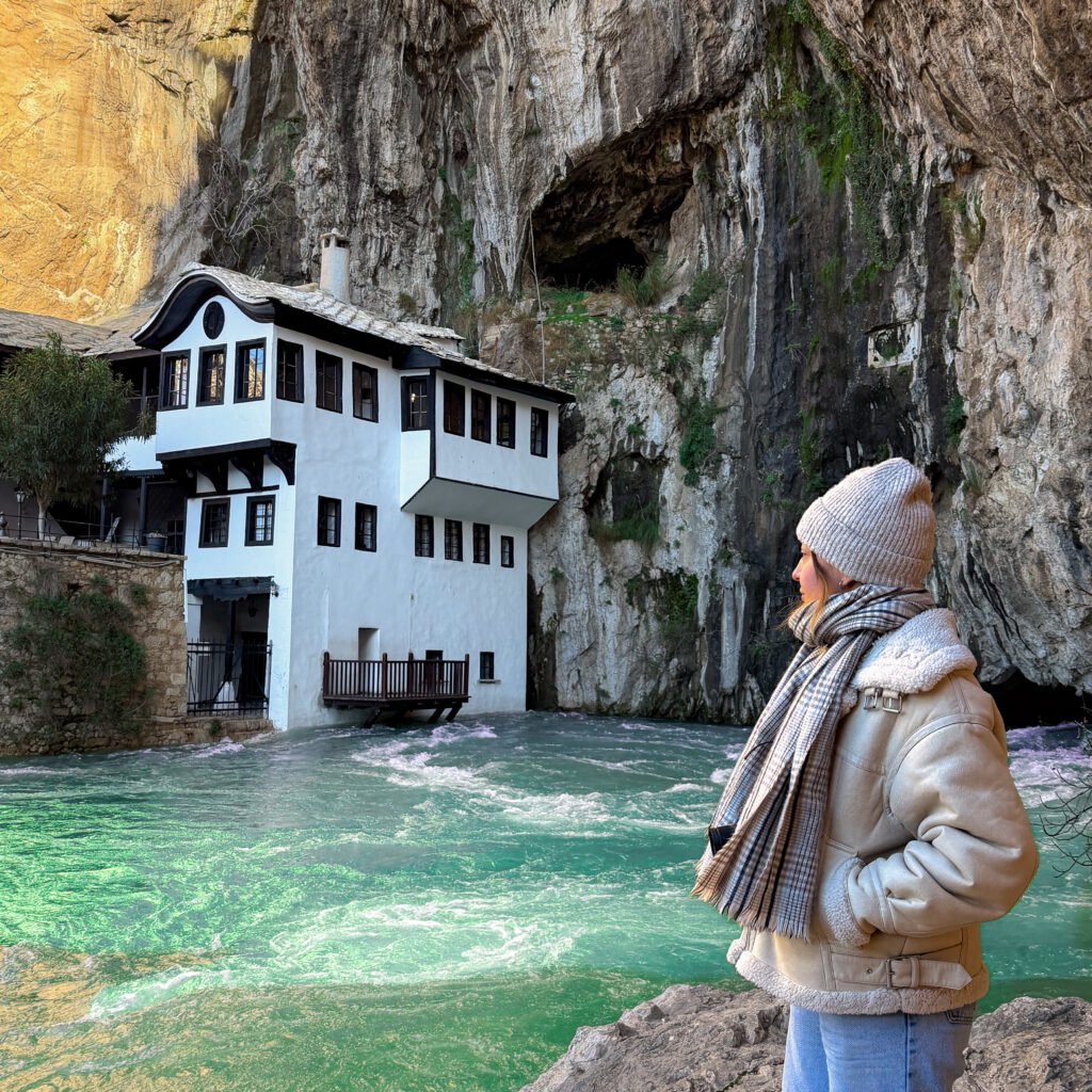 A women stood next to a monastery and green waters on a day trip from Mostar in Herzegovina